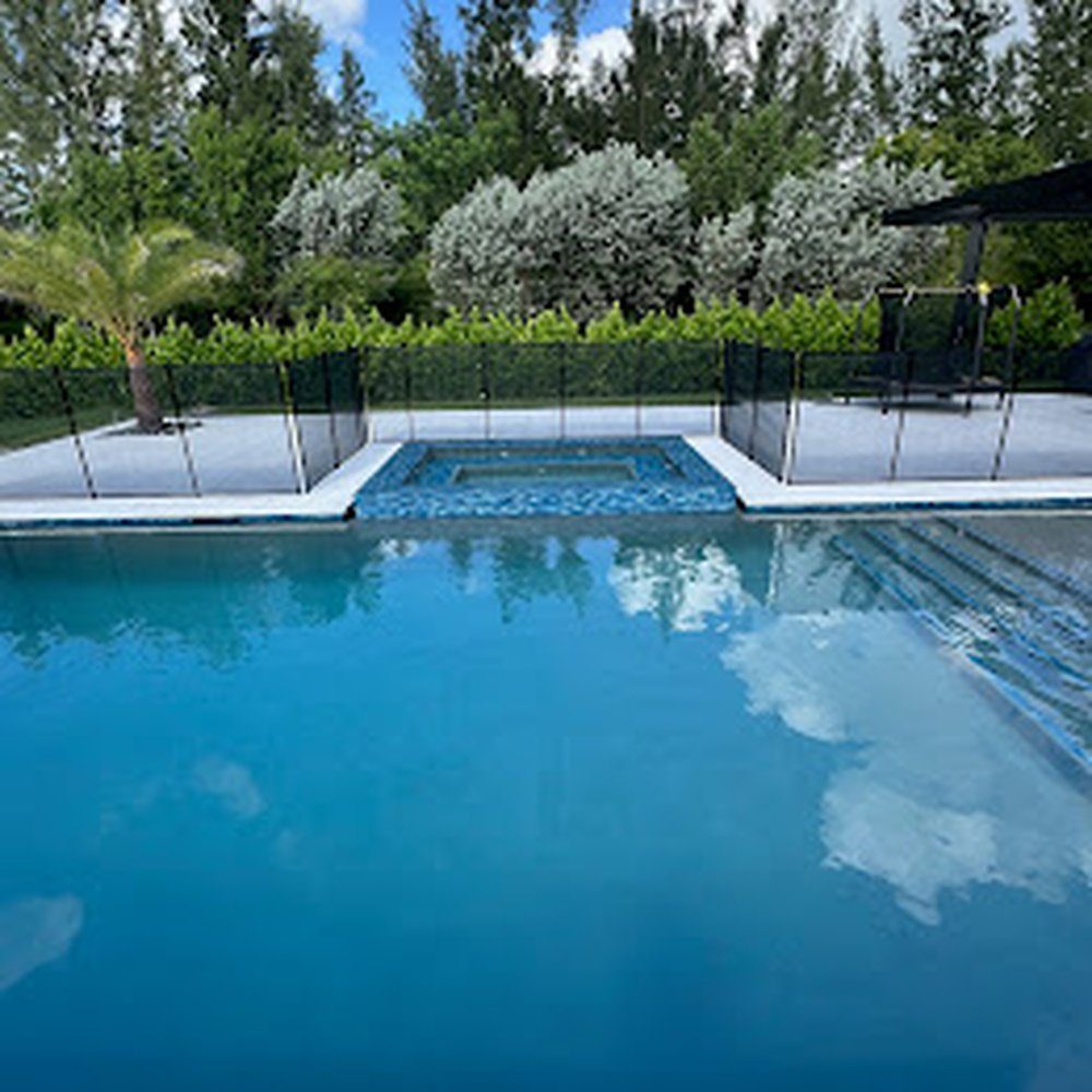 Clear blue pool water framed by a light paver deck