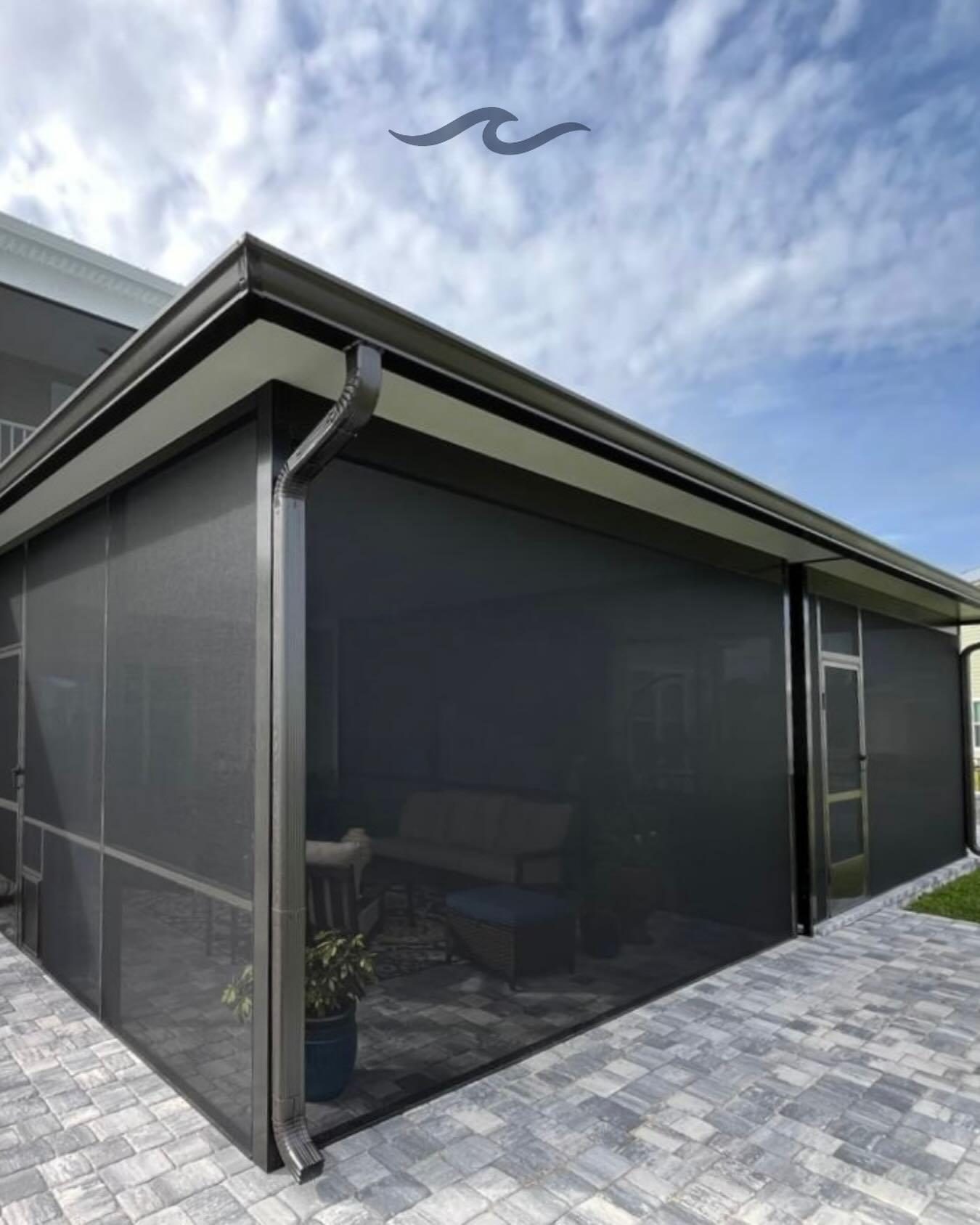 A Marblu-built panoramic screen enclosure over a Florida patio, corner view against the sky