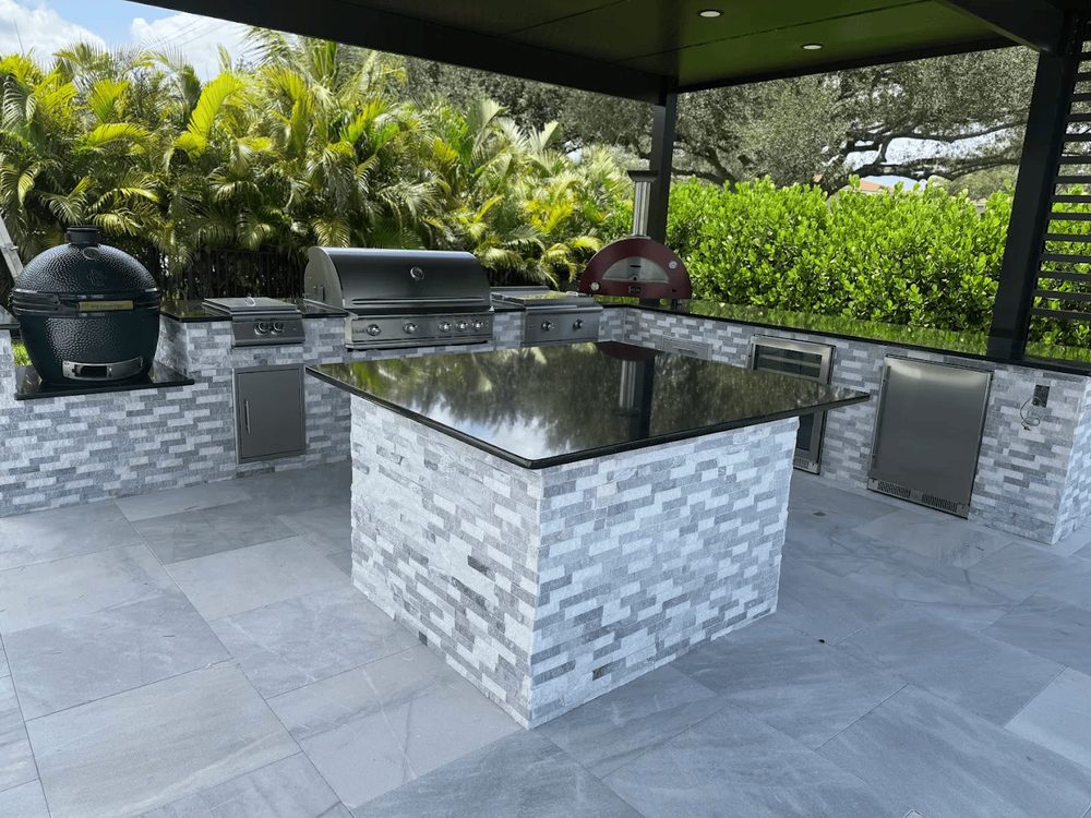 Outdoor kitchen island finished in natural stone tile on a Marblu patio