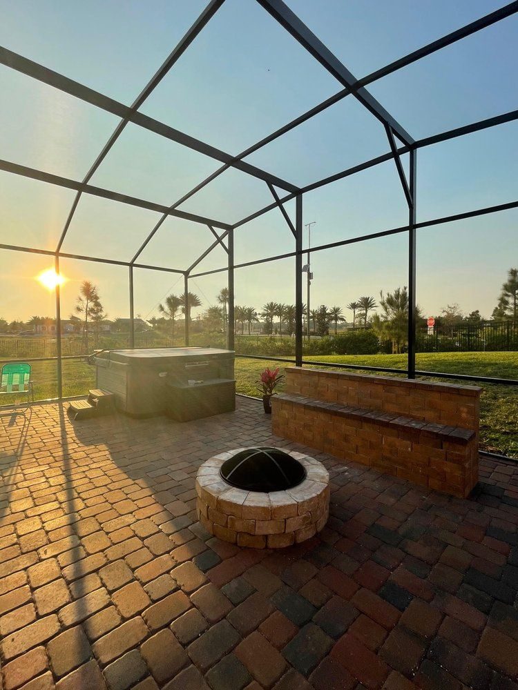 Fire pit glowing at golden hour inside a Marblu screen enclosure