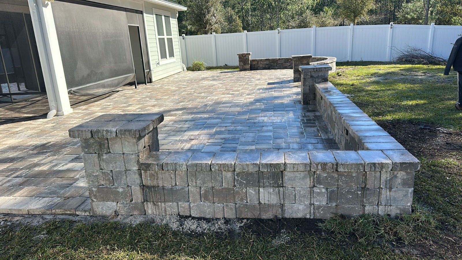 Raised paver patio with built-in fire pit and masonry seating wall