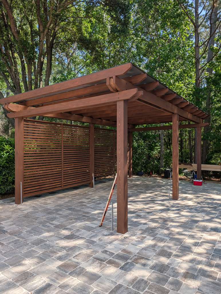 Custom timber pergola with privacy screen over a travertine paver patio in Jacksonville